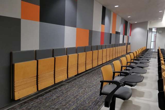 Wall-mounted folding cantilever chair with an engineered wood seat and back.