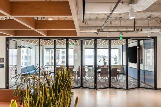 Glass continuous-hinge foldable panel partition in Seattle conference rooms.
