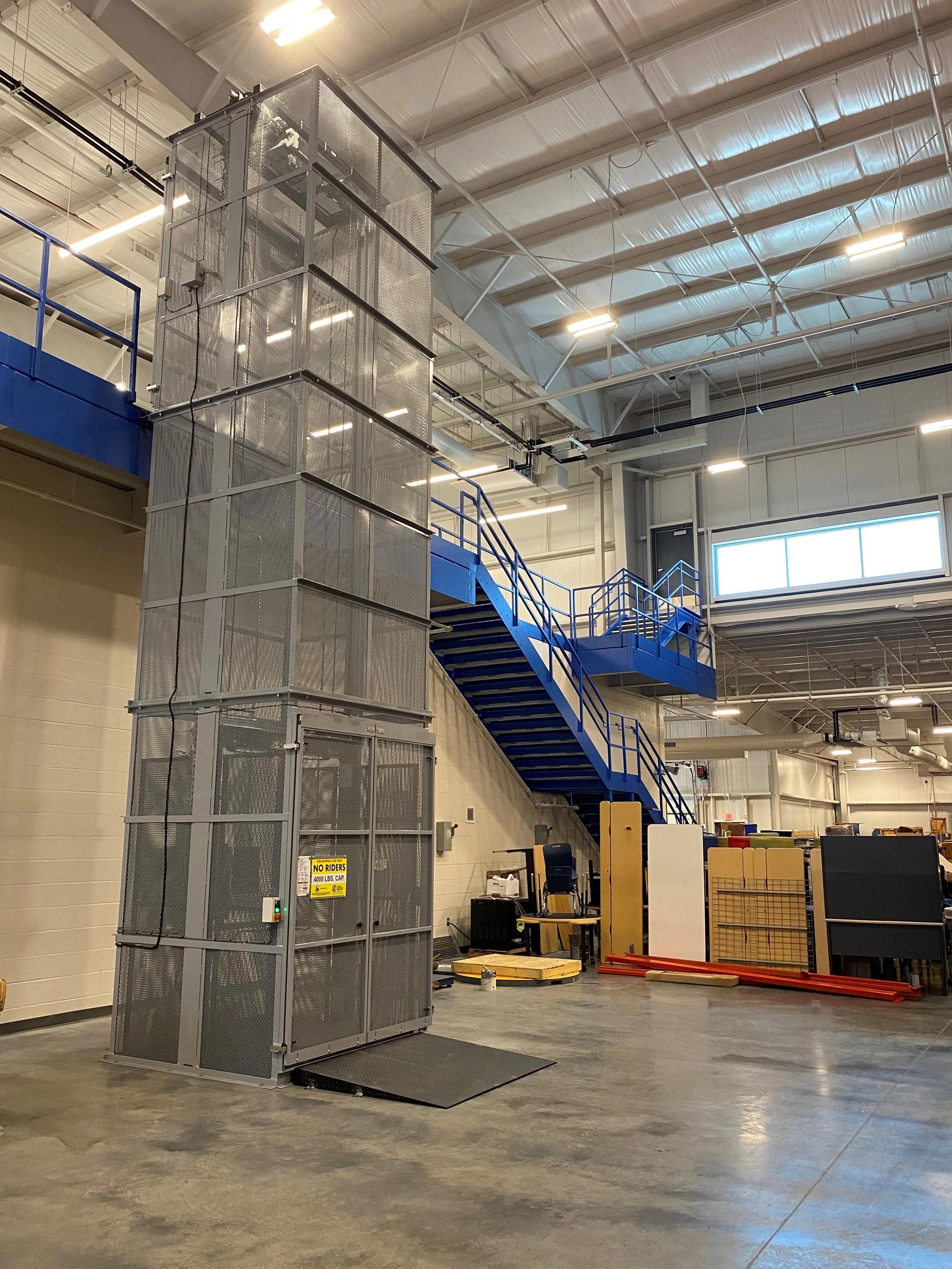 Material handling vertical reciprocating conveyor for moving goods between levels.