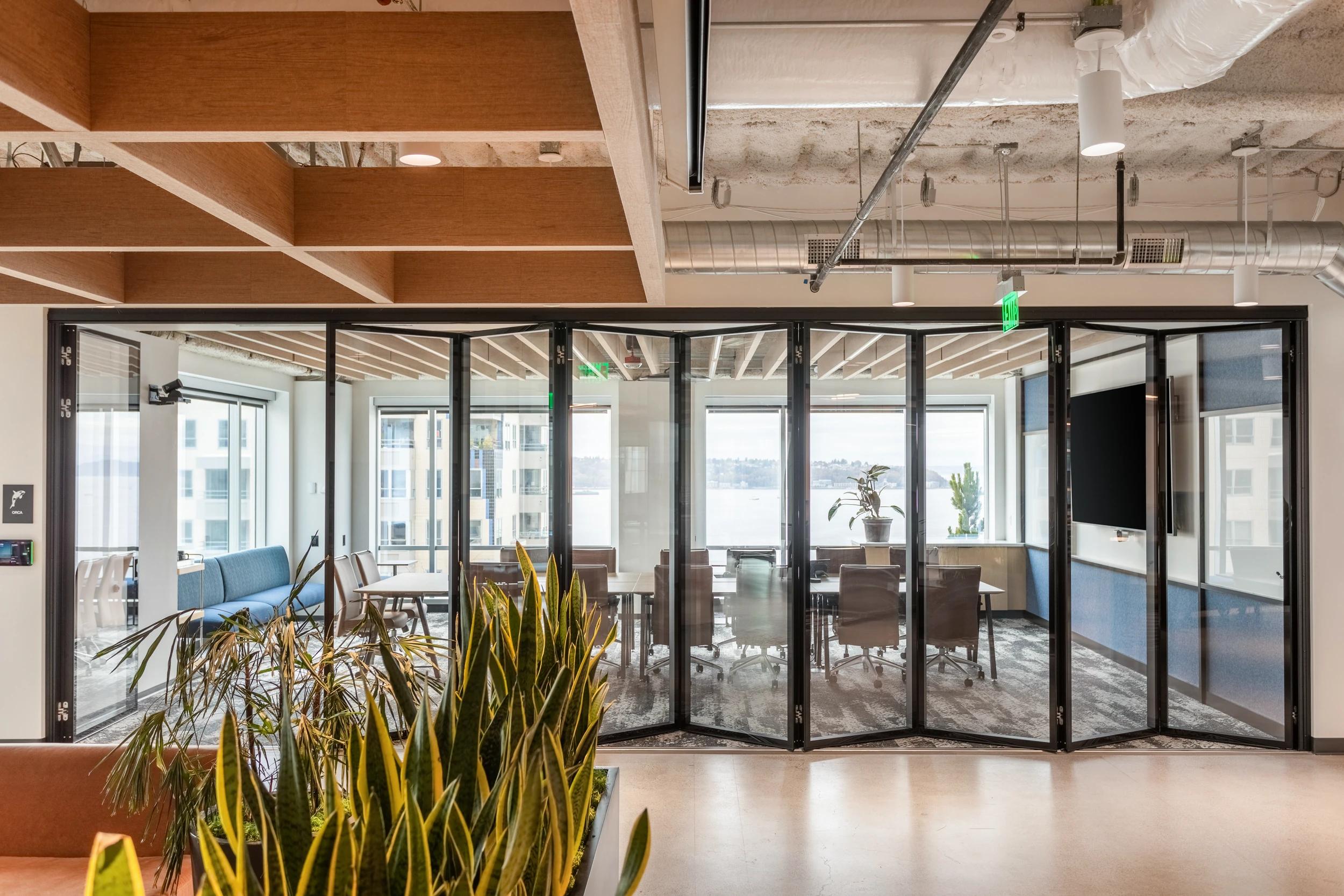 Glass continuous-hinge foldable panel partition in Seattle conference rooms.
