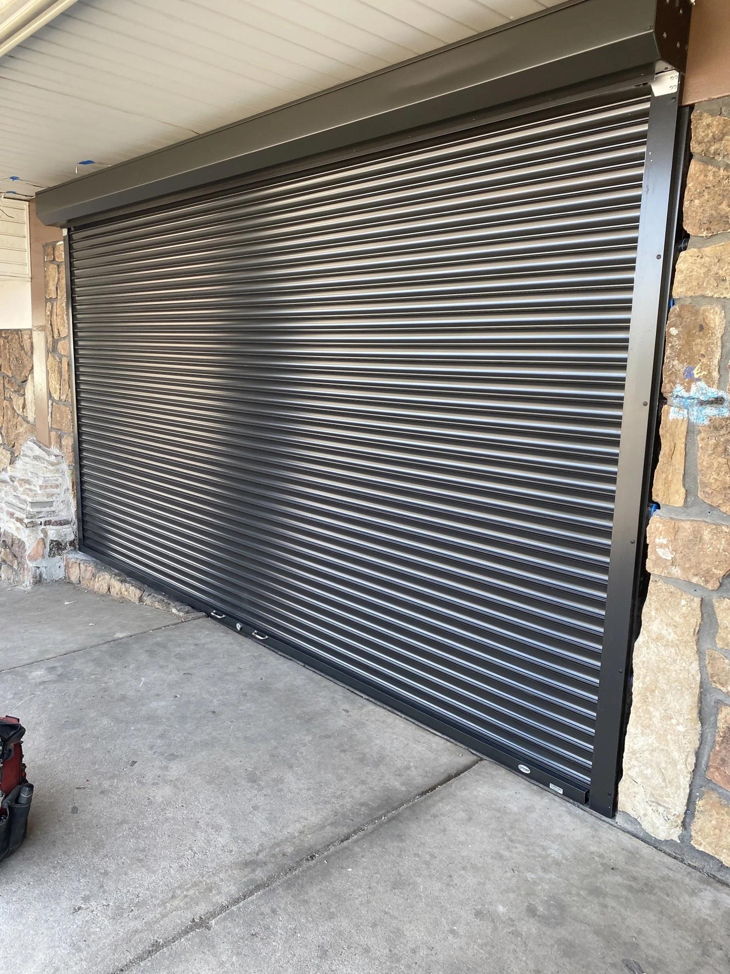 Outdoor security shutter with interlocking metal slats and a reinforced frame.